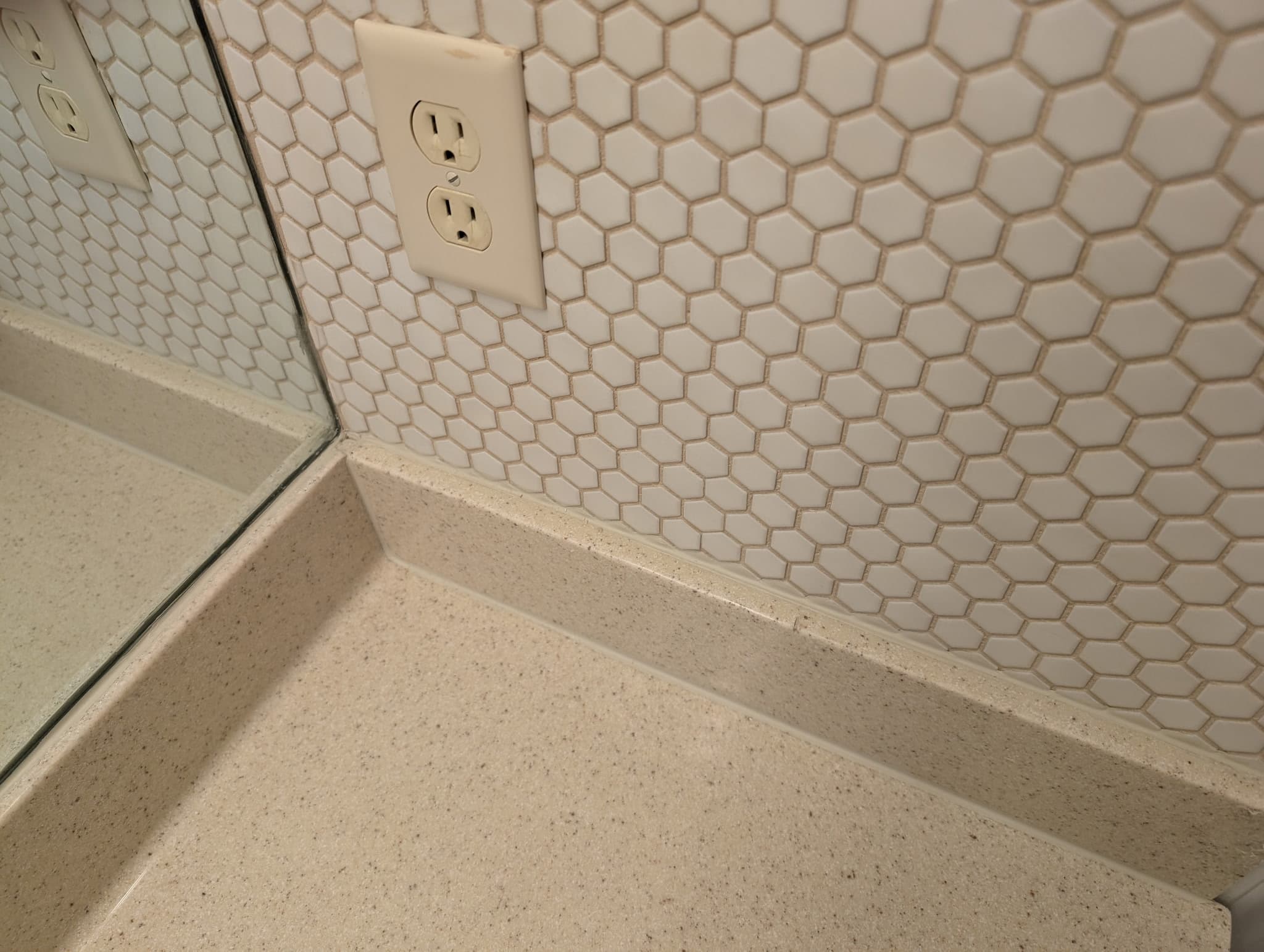 White hexagon mosaic tile backsplash meeting a quartz countertop